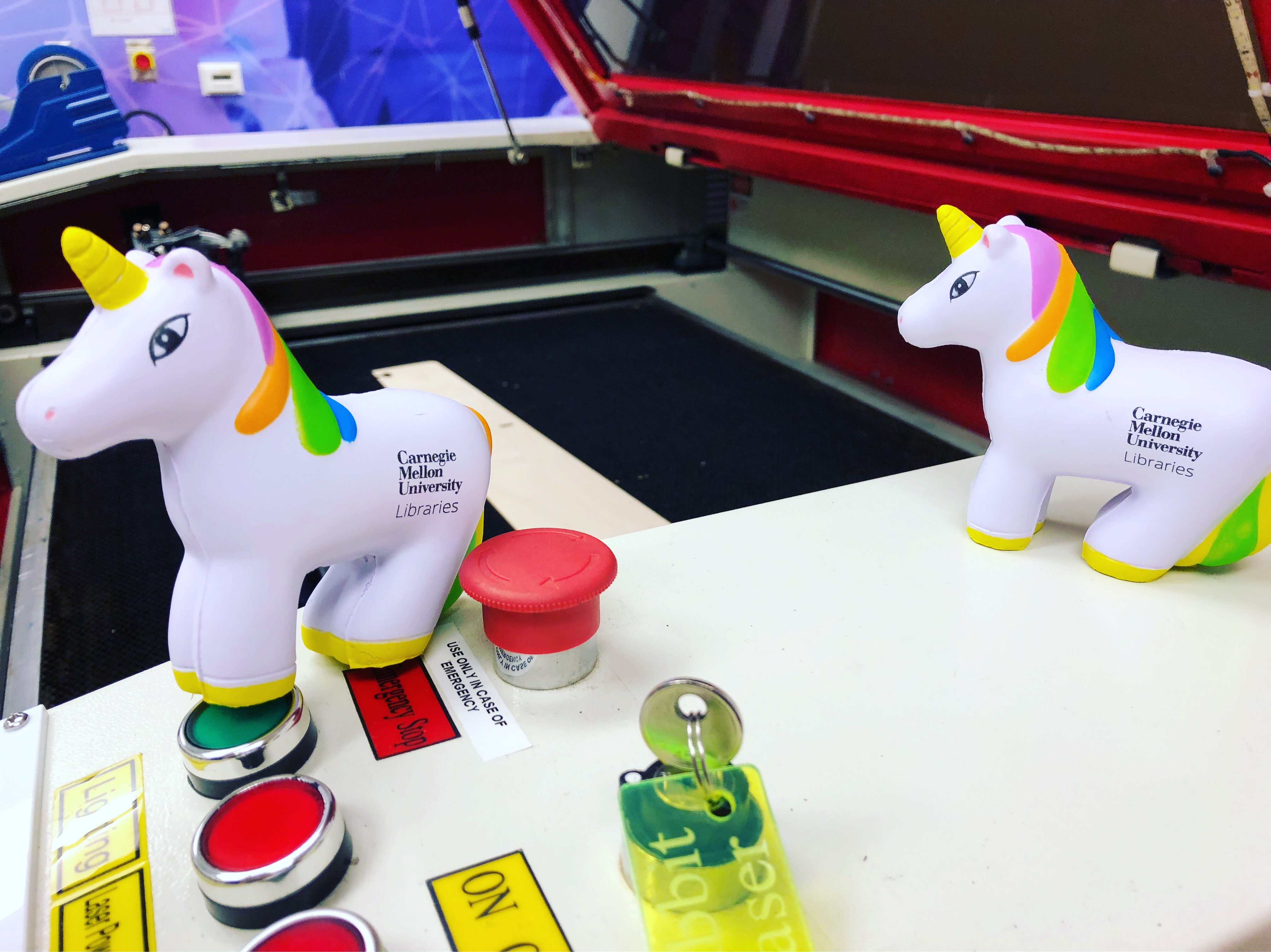 Toy unicorns posed on an IDeATe laser cutter